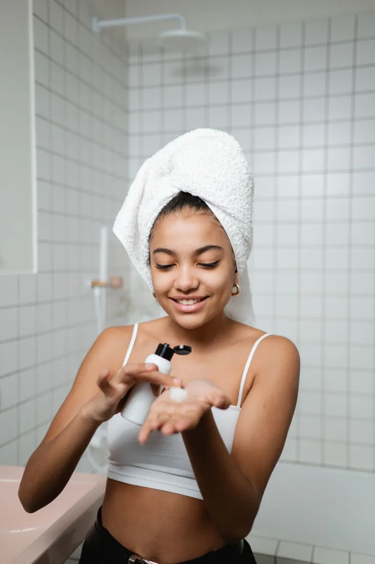 Woman with towel on her head during an at-home LED skincare routine