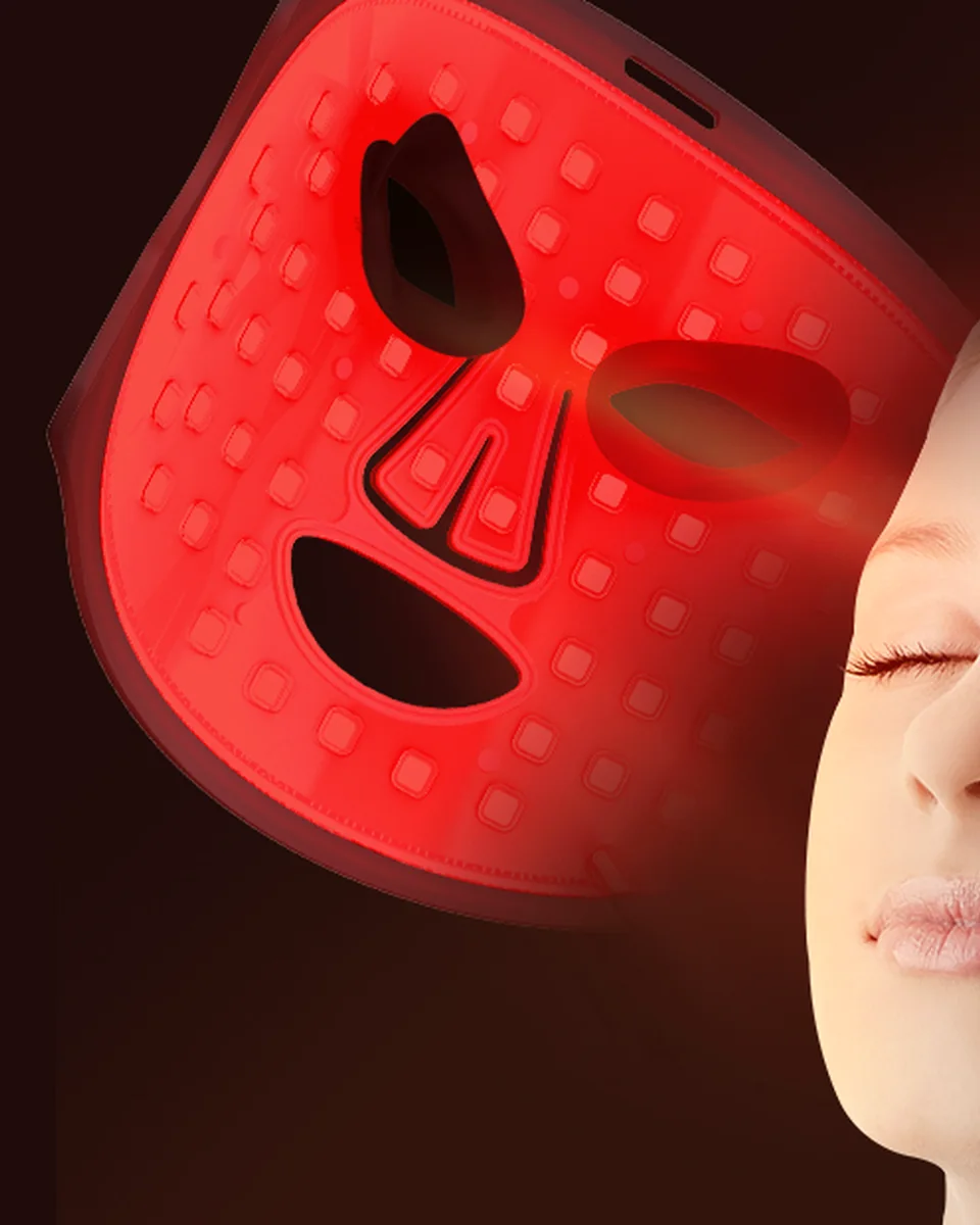 Eyes closed in the red glow of the LED face mask
