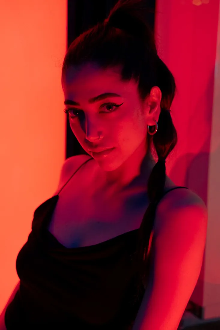 Woman in the warm glow of red light therapy at home